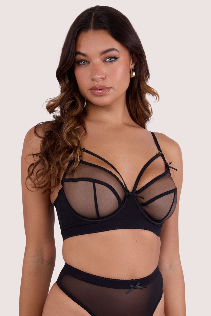 Model wears black mesh longline bra with harness strap detailing and full cups
