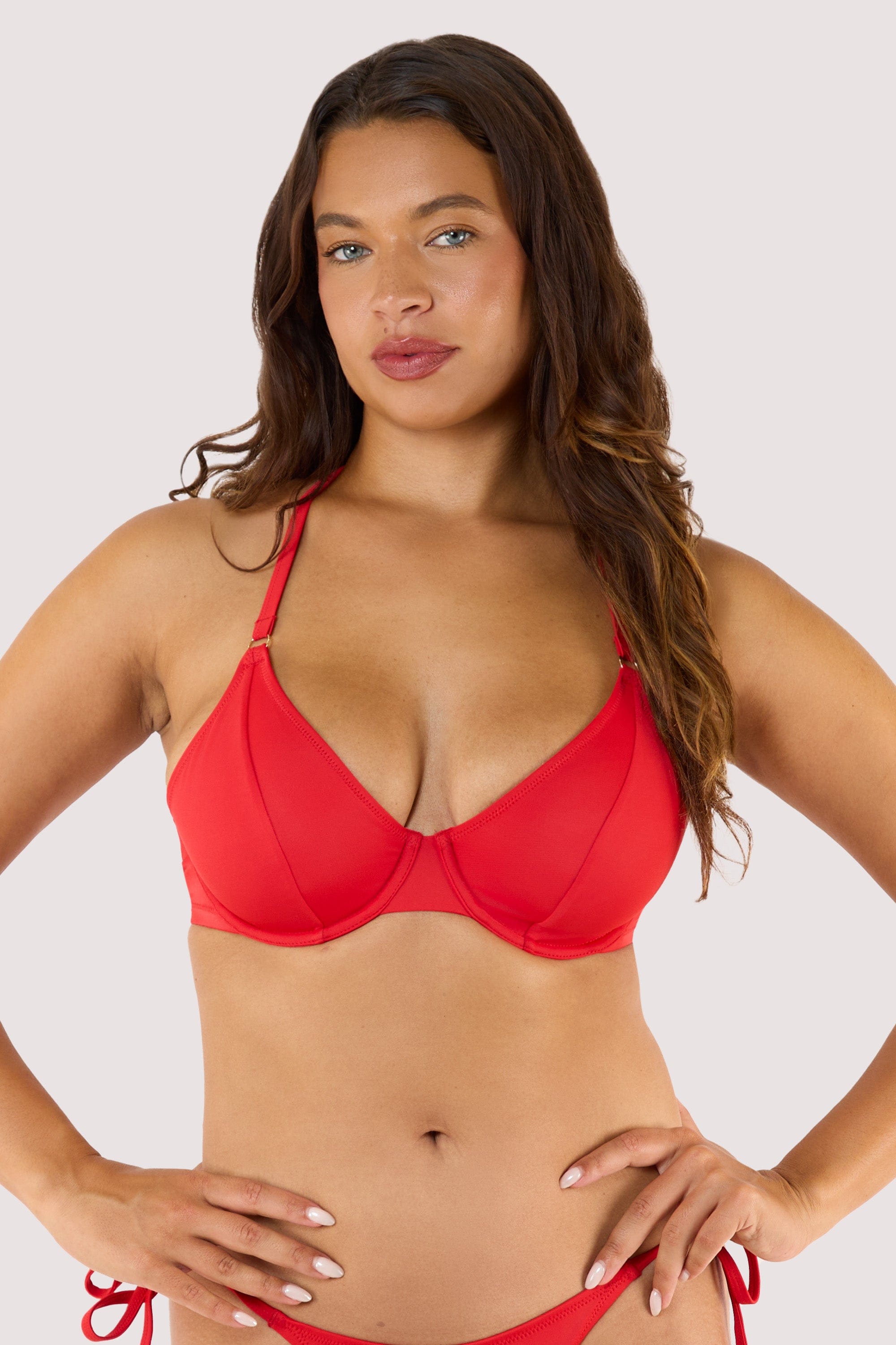 Model wearing a red halter bikini top with underwire support and matching tie-side bikini bottoms.