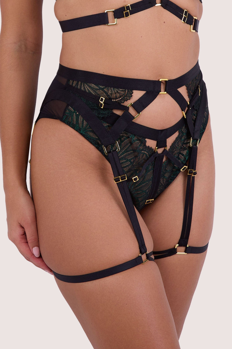Model wears a suspender belt paired with a dark green wet look lace lingerie