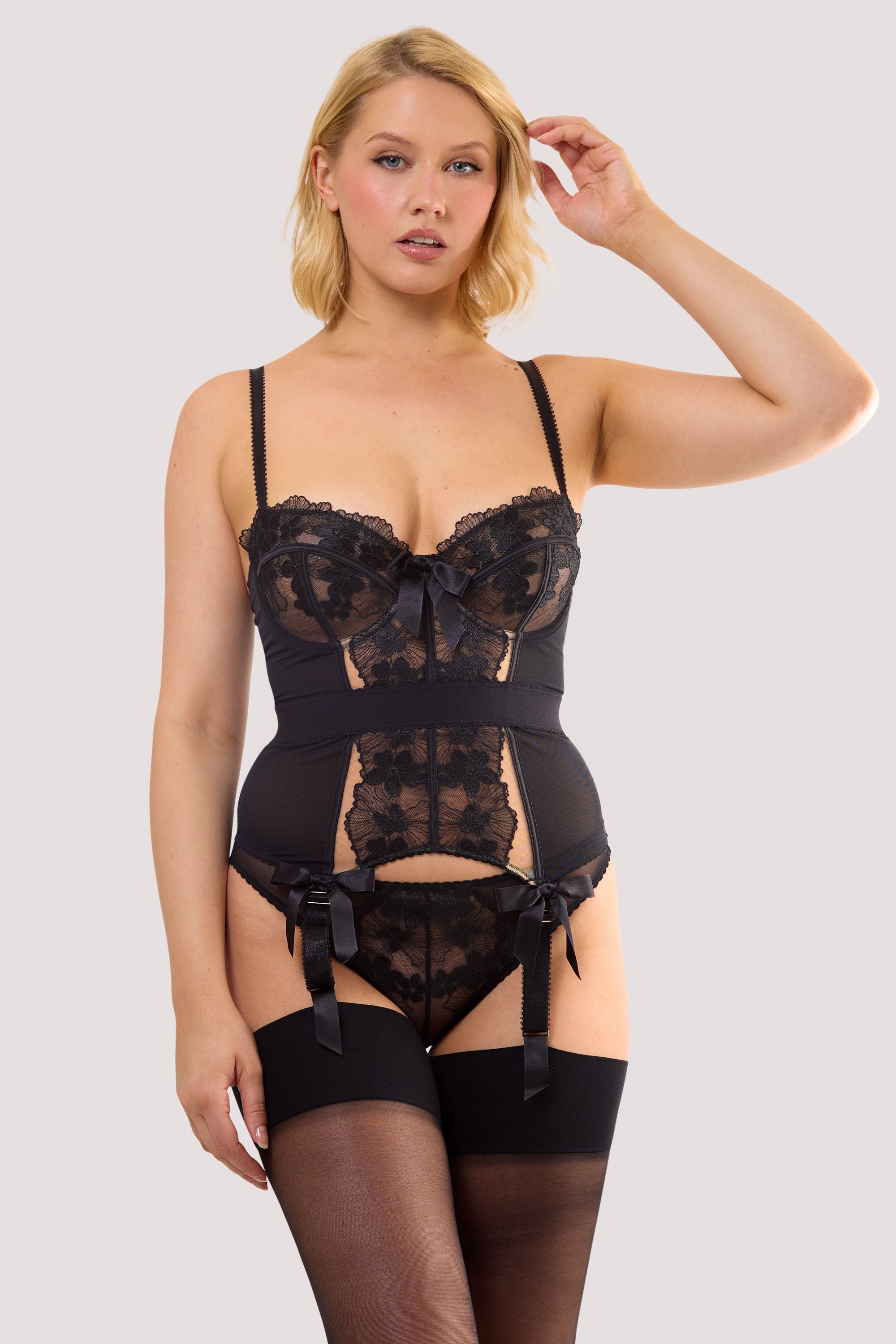 Model wears a black floral embroidery basque with a floral embroidery, satin bows and underwired cups.