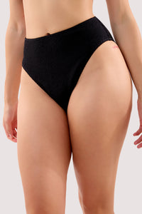Model wears a selene black crinkle high waist bikini bottom with crinkle fabric and high-waist style.