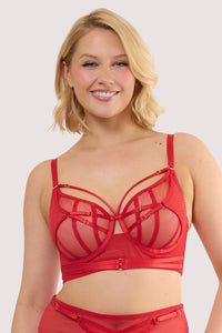 Model wears a eddie ruby red crossover balconette bra with sheer mesh and fishnet panels and underwired balconette cups.