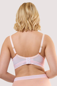 Model shows the back of a icon blush pink microfiber moulded cup bra with adjustable shoulder straps and hook and eye fastener.