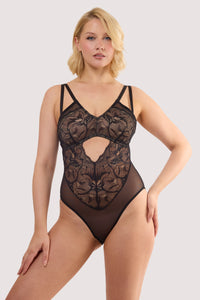 Model wears a ariella black graphic lace body with sheer mesh with graphic lace overlay featuring plunge neckline and high-leg cut.