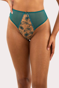 Model wears a teal mesh high-waist thong with floral embroidery details