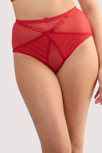 Model wears a eddie ruby red crossover high waist brief with ruby red mesh and fishnet panels and full brief style.