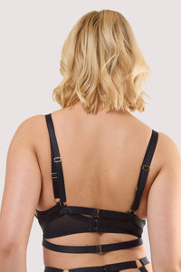 Model shows a back of black straps and gold hardware, emphasizing adjustable straps and a sleek silhouette.