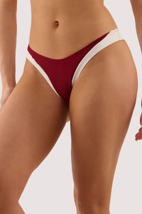 Model wears a stasia wine and ivory high leg brief with ivory contrast trim and High-waist, high-leg style.