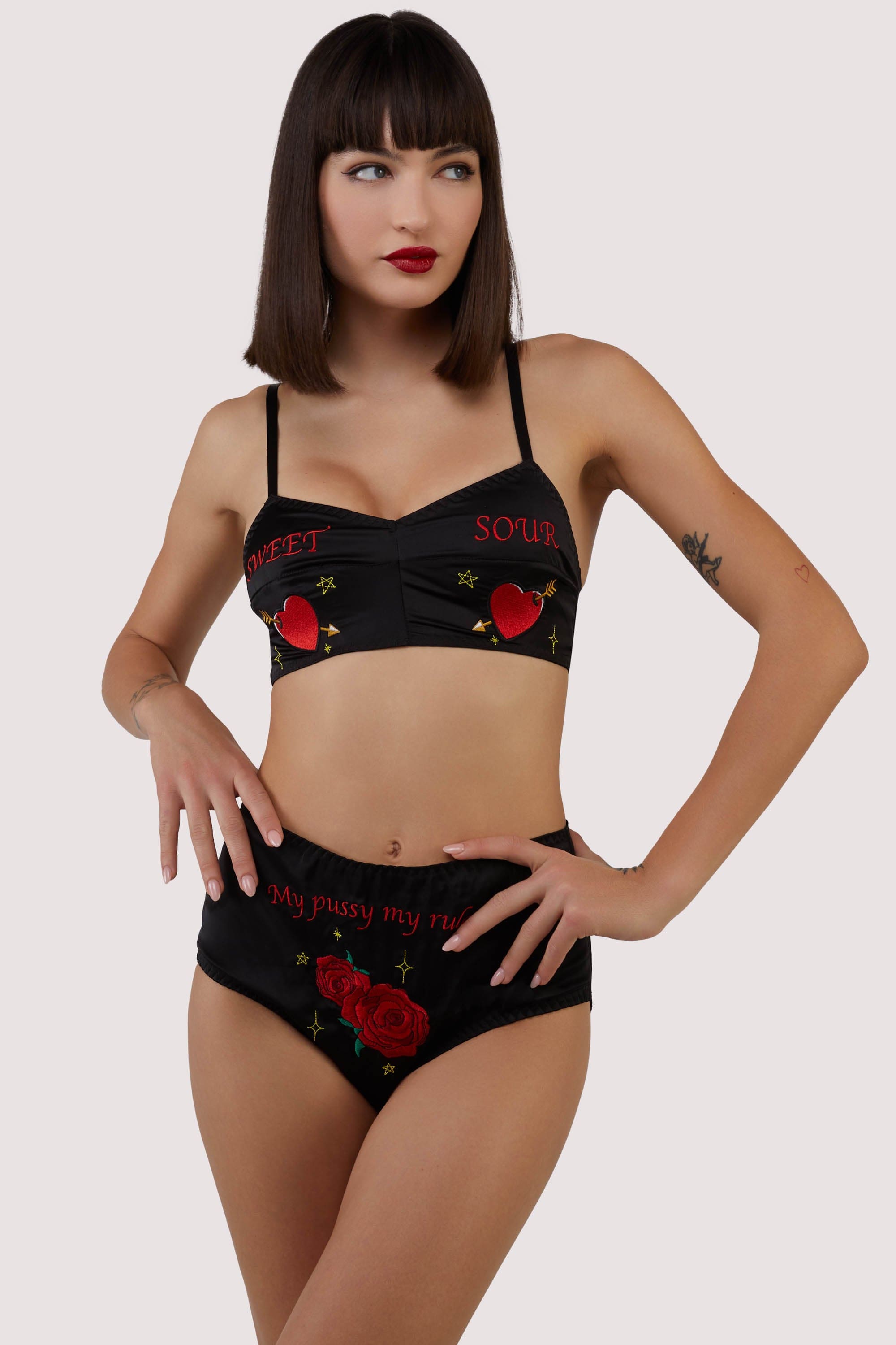 model wears black satin bralette and high-waisted briefs with retro embroidery