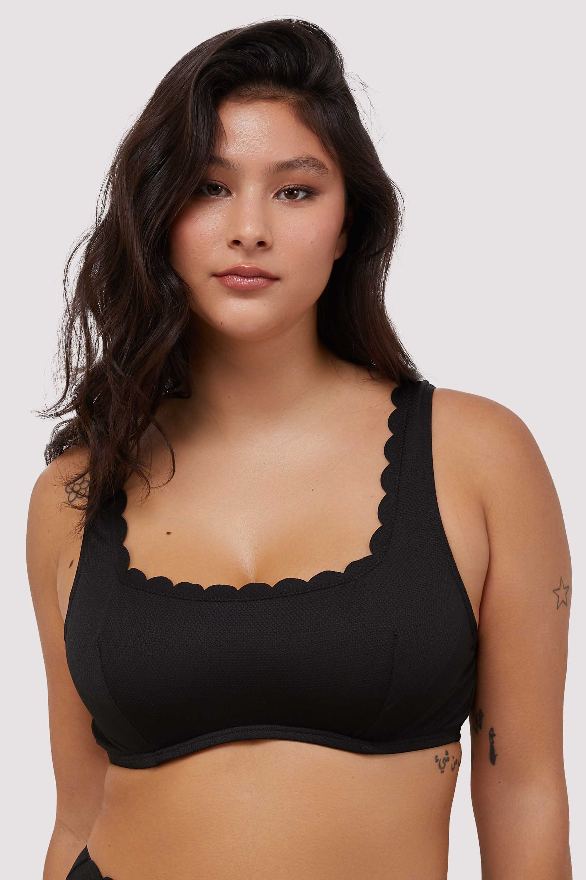 model wears black scalloped underwire balconette bikini top with thick shoulder straps