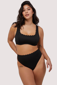 model wears black scalloped underwire balconette bikini top with matching high leg bottoms swimwear set