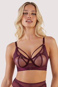 Harness style bra with mesh overlay and visible gold hardware in a deep wine red/purple.