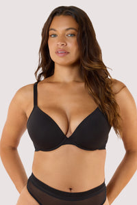 Model wears Black Microfiber Moulded Cup Bra showing full moulded cups, underwire support, and linear trim detailing.