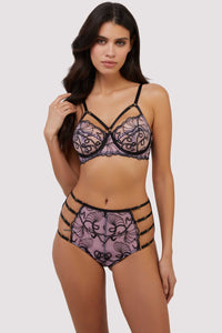 model wears pink and black embroidered bra and high-waisted brief set