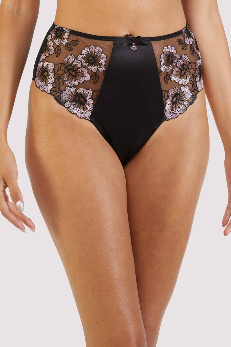 Black satin underwear with delicate black and pale pink floral embroidery on a mesh body.