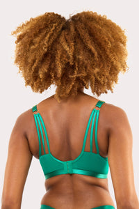 Model shows back of green plunge lace bra with decorative straps