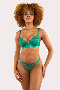 Model wears forest green embroidered plunge bra with scalloped lace and gold hardware, styled with matching thong