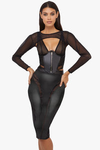 Model wears a black vegan leather mesh insert pencil skirt featuring leather panels with sheer mesh inserts with waist cinching, silhouette defining fit, with a matching shrug and underbust corset.