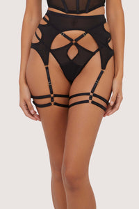 Model Wears a thong with a Cut-Out Suspender in Black Mesh with Strap Detailing