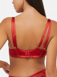 Model shows the back of red plunge bra with hook and eye fastener, adjustable shoulder straps and swan clip harness closure